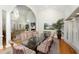 Open-concept dining room with a large glass table, striped chairs, and views of backyard from large windows at 65 Surfsong Rd, Kiawah Island, SC 29455