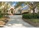 Stunning home featuring manicured landscaping, a circular driveway, and grand entrance with elegant architectural details at 65 Surfsong Rd, Kiawah Island, SC 29455