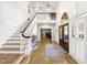 Bright foyer featuring high ceilings, wood floors, stairs, and a formal entryway with a rug at 65 Surfsong Rd, Kiawah Island, SC 29455