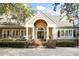 Elegant front entrance with brick steps, a covered porch, and beautifully designed double doors at 65 Surfsong Rd, Kiawah Island, SC 29455