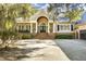 Elegant home with a welcoming front porch, manicured landscaping and spacious driveway at 65 Surfsong Rd, Kiawah Island, SC 29455