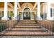 Inviting front porch with brick steps, black railings and arched entryway at 65 Surfsong Rd, Kiawah Island, SC 29455