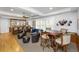 Game room with a built-in bar, hardwood table with chairs, leather club chairs, and a couch at 65 Surfsong Rd, Kiawah Island, SC 29455