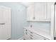 Functional laundry area with white cabinets, countertop, sink, and storage solutions at 65 Surfsong Rd, Kiawah Island, SC 29455