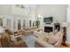 Comfortable living room with plush sofas, fireplace, and access to outdoor area through large windows at 65 Surfsong Rd, Kiawah Island, SC 29455