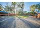 Spacious backyard features a gravel drive, grassy yard, stepping stone walkway, swimming pool, and covered parking at 676 Sterling Dr, Charleston, SC 29412