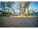 Expansive backyard featuring mature trees, a storage building, a trampoline, and a charming fenced perimeter at 676 Sterling Dr, Charleston, SC 29412