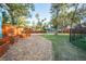 Backyard showing planting beds, a grassy area, a fenced yard, and a covered parking area at 676 Sterling Dr, Charleston, SC 29412