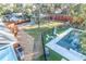 Aerial view of a backyard featuring a pool, yard with mature trees, planting beds, and charming fence at 676 Sterling Dr, Charleston, SC 29412