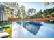 Relaxing backyard pool featuring a tanning ledge, modern tile, and lush landscaping at 676 Sterling Dr, Charleston, SC 29412