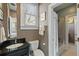Well-lit bathroom features a sleek black granite vanity and shower over tub at 7 West St # C, Charleston, SC 29401
