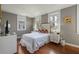 Bright bedroom with white trim, hardwood floors and floral bedding create a cozy retreat at 7 West St # C, Charleston, SC 29401