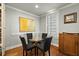 Bright breakfast nook features a modern glass table, stylish chairs, and sunny window with wooden shutters at 7 West St # C, Charleston, SC 29401