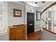Foyer with wood floors, staircase, front door with stained glass, and antique cabinet at 7 West St # C, Charleston, SC 29401