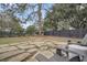 Large backyard featuring a stone patio area, lush greenery, and privacy fencing at 739 Shamrock Ln, Charleston, SC 29412