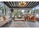 Bright sunroom with a chandelier, seating area, and a custom-made bar with unique decor details at 739 Shamrock Ln, Charleston, SC 29412