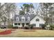 Charming two-story home with a cozy front porch and a well-manicured lawn and landscaped yard at 8656 Laurel Grove Ln, North Charleston, SC 29420