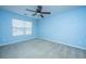 Bright bedroom with blue walls, ceiling fan, and a large window at 8857 Gable St, North Charleston, SC 29406