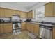 Well-equipped kitchen with stainless steel appliances, wood cabinets, and ample countertop space at 8957 N Red Maple Cir, Summerville, SC 29485