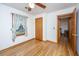 Bedroom with hardwood floors, ceiling fan, window with floral curtains and wood door at 904 Randall Dr, Mount Pleasant, SC 29464