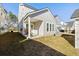 View of the house's back yard with a covered patio, green grass, and nice windows at 109 Osprey Ridge Ln, Summerville, SC 29483