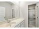 A sleek bathroom with a white vanity, a large mirror and an open door showing a shower-tub combo at 109 Osprey Ridge Ln, Summerville, SC 29483