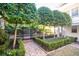 Landscaped backyard featuring pool, trees, manicured hedges, and brick walkway at 11 Church St, Charleston, SC 29401