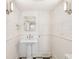 Elegant bathroom features patterned wallpaper, pedestal sink, and black and white tile flooring at 11 Church St, Charleston, SC 29401
