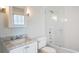 A bright bathroom with a glass shower, tub, and marble countertop vanity at 11 Church St, Charleston, SC 29401