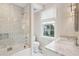 A stylish bathroom with a marble vanity, patterned wallpaper, and a glass-enclosed shower at 11 Church St, Charleston, SC 29401