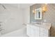 A pristine white bathroom with a tiled shower/tub and a marble vanity at 11 Church St, Charleston, SC 29401