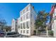 A charming white clapboard home with gray shutters sits beneath a clear blue sky at 11 Church St, Charleston, SC 29401