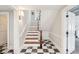 A hallway and staircase featuring hardwood steps, a white banister, and black and white checkered floor at 11 Church St, Charleston, SC 29401
