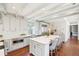 Bright kitchen with large island seating, marble counters, exposed beam ceiling and stainless appliances at 11 Church St, Charleston, SC 29401