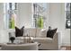 Sunlit living room features a comfortable sofa, large windows, and green outdoor views at 11 Church St, Charleston, SC 29401