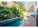 In-ground pool surrounded by brick, lush greenery, and a charming backyard oasis at 11 Church St, Charleston, SC 29401