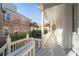 Inviting covered porch showcases white railings, hanging plants, and view of surrounding greenery at 11 Church St, Charleston, SC 29401