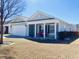 Inviting single-story home with a covered porch featuring red rocking chairs, complemented by a well-maintained lawn at 113 Mayfield Dr, Goose Creek, SC 29445