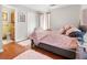 Cozy bedroom featuring a pink bed, wood floors, and a glimpse into the adjacent bathroom at 116 Lyle Rd, Goose Creek, SC 29445