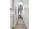 Hallway with wood floors and a geometric runner leads to various rooms with modern lighting at 116 Lyle Rd, Goose Creek, SC 29445