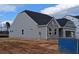 A single story home with gray siding and stone accents, situated on a lot with a large concrete driveway at 119 Palfrey Dr, Ridgeville, SC 29472