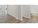 Hallway with wood-look flooring leading to a bathroom and other rooms with lots of natural light at 119 Palfrey Dr, Ridgeville, SC 29472