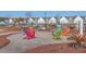 Community firepit with multicolored Adirondack chairs and landscaping near community homes at 131 Summer Tanager Dr, Ravenel, SC 29470