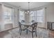 Bright dining room featuring a modern chandelier, large windows, and stylish decor at 131 Summer Tanager Dr, Ravenel, SC 29470