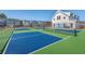Community blue and green pickleball courts surrounded by black fencing and landscaping at 131 Summer Tanager Dr, Ravenel, SC 29470