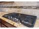 A stainless steel cooktop with black grates sits atop granite countertops at 144 Clark Ln, Summerville, SC 29483