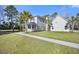 View of home showing manicured lawn, palm trees, and well-maintained exterior, highlighting its curb appeal at 144 Clark Ln, Summerville, SC 29483