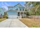 Charming blue two-story home with a front porch, white trim, and a well-manicured lawn at 1601 Secessionville Rd, Charleston, SC 29412