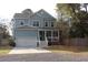 Charming two story home with blue siding, a covered front porch, and a white two car garage at 1601 Secessionville Rd, Charleston, SC 29412