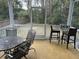 View of outdoor screened porch with bar height table and chairs and an additional seating area at 1601 Secessionville Rd, Charleston, SC 29412
